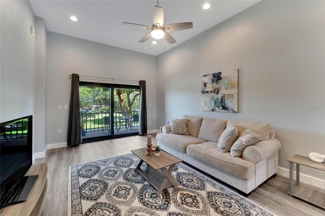 living room featuring ceiling fan and light hardwood / wood-style flooring