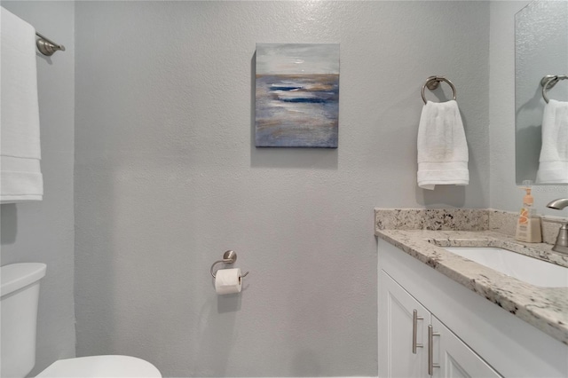 bathroom featuring toilet and vanity