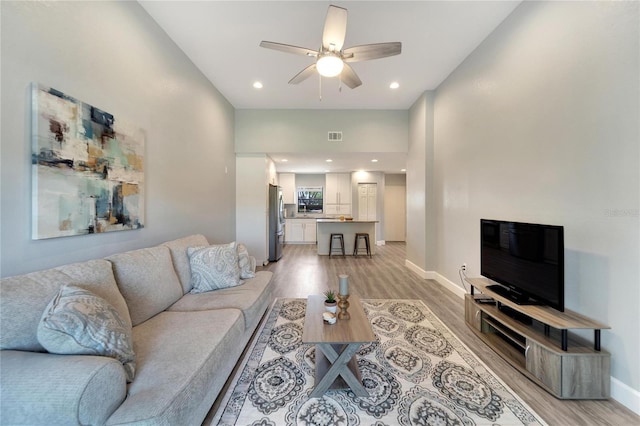 living room with ceiling fan and light hardwood / wood-style floors