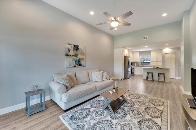 living room with light wood-type flooring and ceiling fan