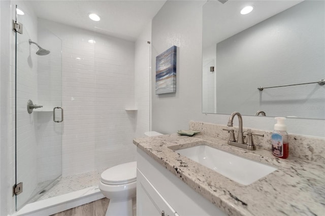 bathroom with walk in shower, toilet, hardwood / wood-style flooring, and vanity