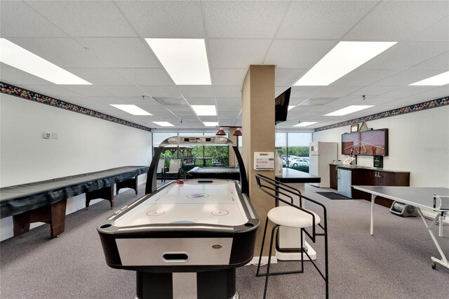 recreation room featuring a paneled ceiling and carpet