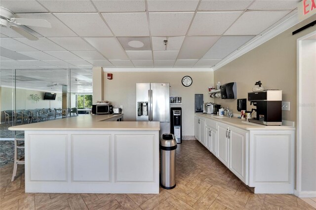 kitchen featuring stainless steel appliances, ornamental molding, white cabinetry, light parquet flooring, and ceiling fan