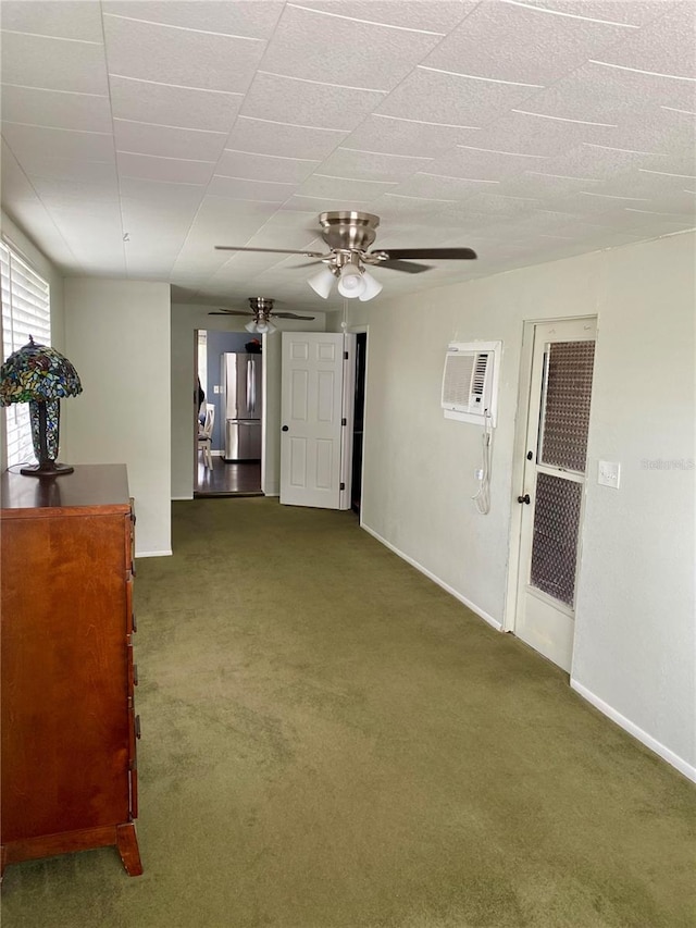 empty room featuring a wall mounted air conditioner, ceiling fan, and carpet flooring