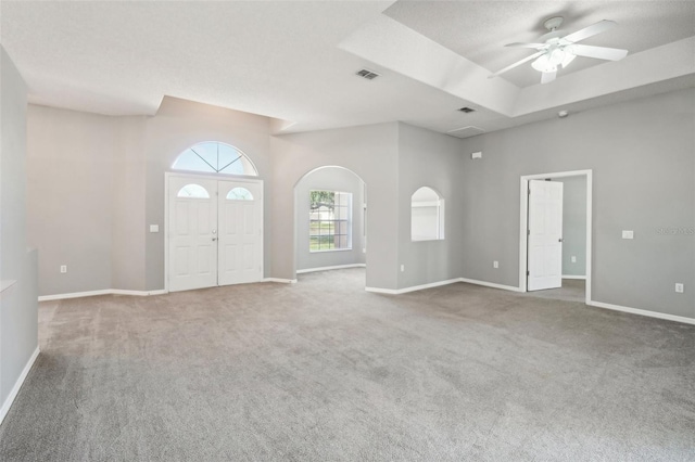 interior space featuring ceiling fan, carpet floors, and a high ceiling