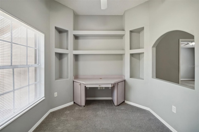 interior space with ceiling fan, a healthy amount of sunlight, and built in shelves