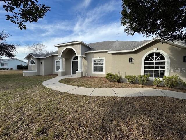 single story home with a front lawn