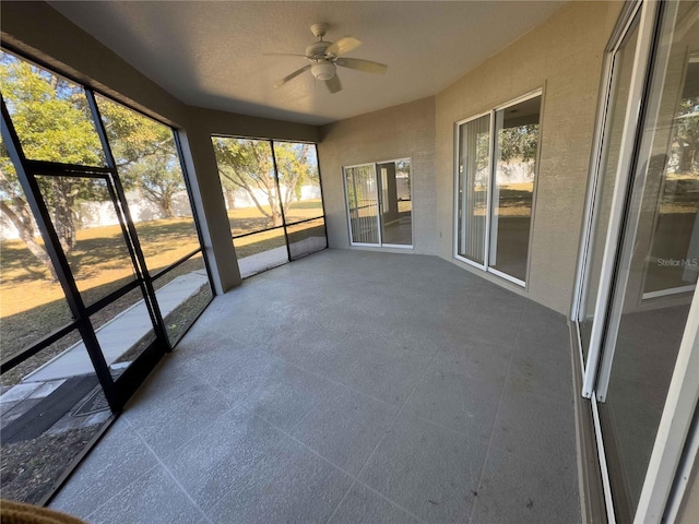 unfurnished sunroom with ceiling fan