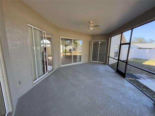 unfurnished sunroom with ceiling fan