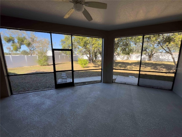 unfurnished sunroom featuring ceiling fan