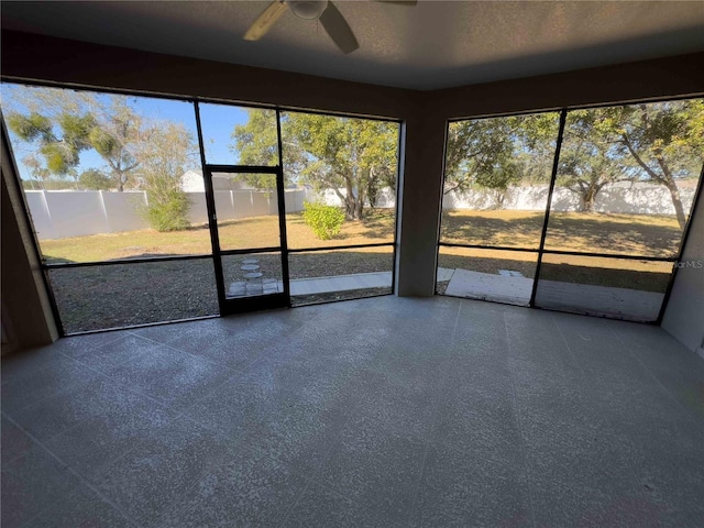 unfurnished sunroom featuring ceiling fan