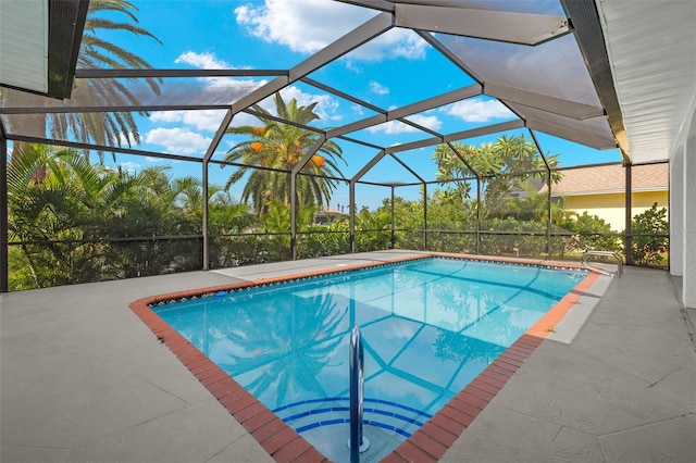 view of swimming pool with glass enclosure and a patio