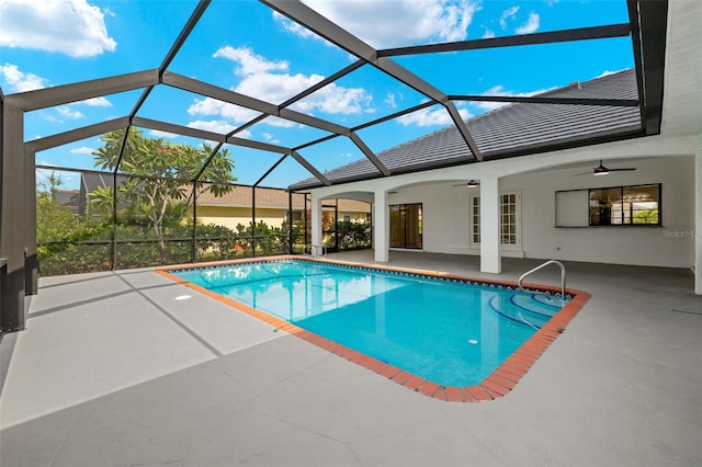 view of pool with glass enclosure, a patio, and ceiling fan