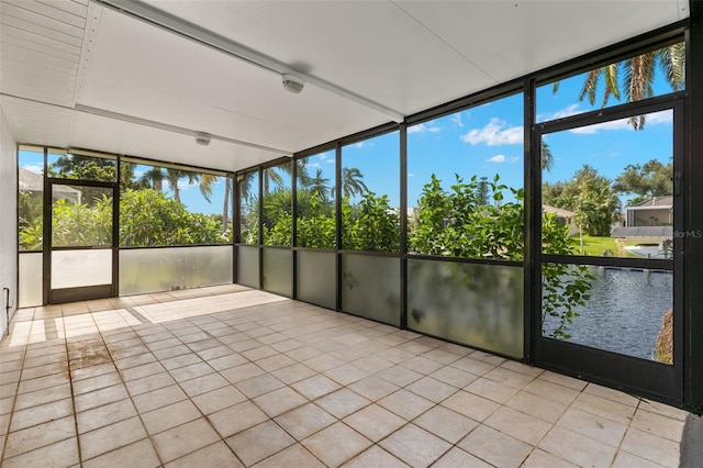 unfurnished sunroom with a water view