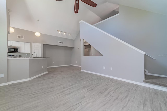 unfurnished living room featuring high vaulted ceiling, visible vents, light wood finished floors, and a ceiling fan