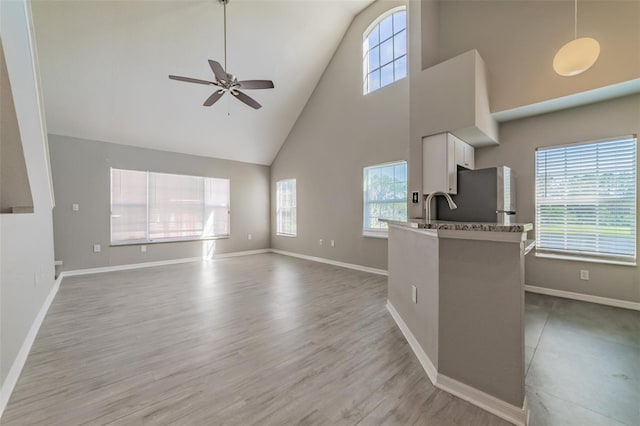 living room with light wood-style flooring, baseboards, and a ceiling fan