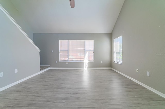 empty room featuring vaulted ceiling, hardwood / wood-style floors, and ceiling fan