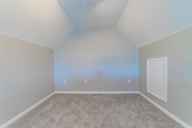 bonus room featuring lofted ceiling, carpet flooring, and baseboards