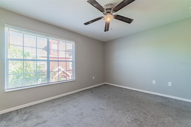 carpeted empty room with a wealth of natural light and ceiling fan