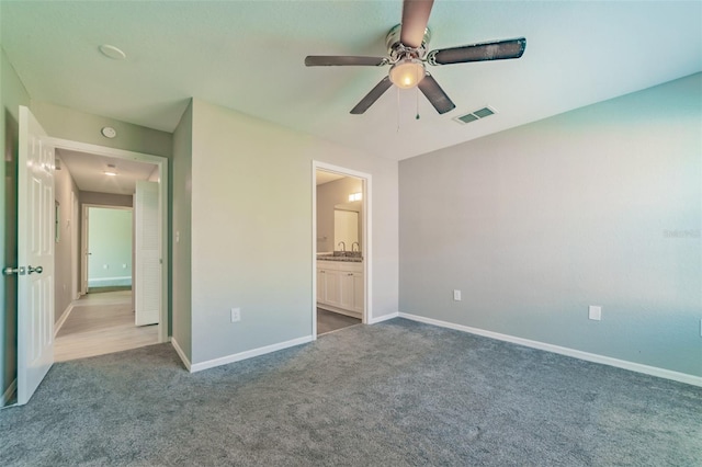 unfurnished bedroom featuring connected bathroom, carpet floors, a sink, visible vents, and baseboards