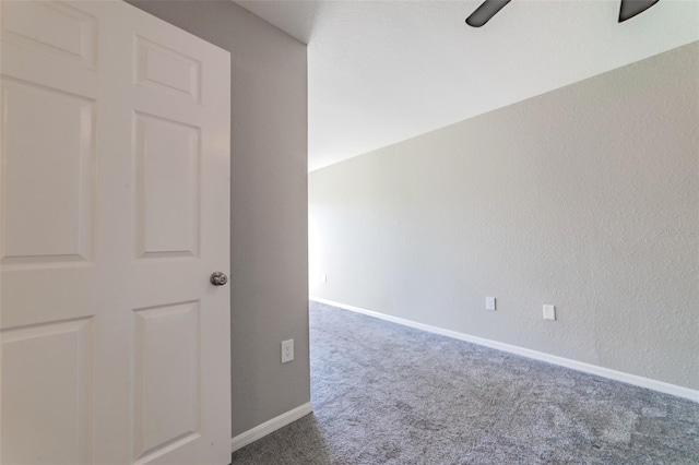 carpeted empty room with baseboards and a textured wall