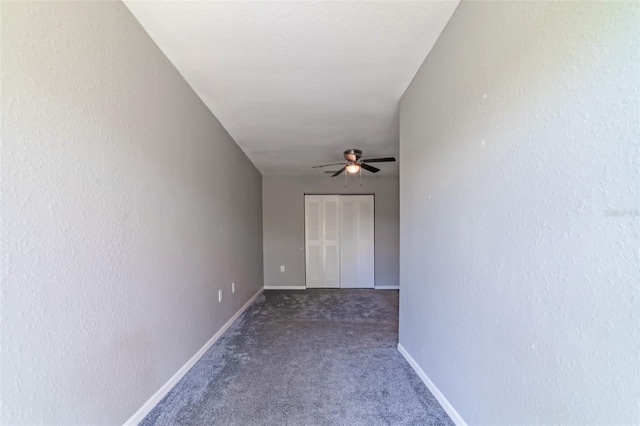 spare room with carpet floors, baseboards, a ceiling fan, and a textured wall