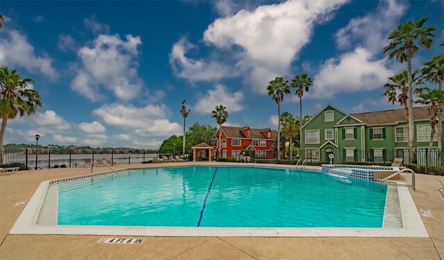 community pool with fence and a residential view