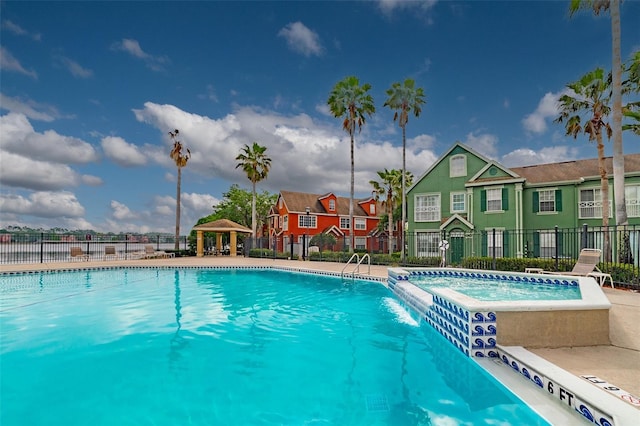 community pool with a gazebo, fence, and a residential view