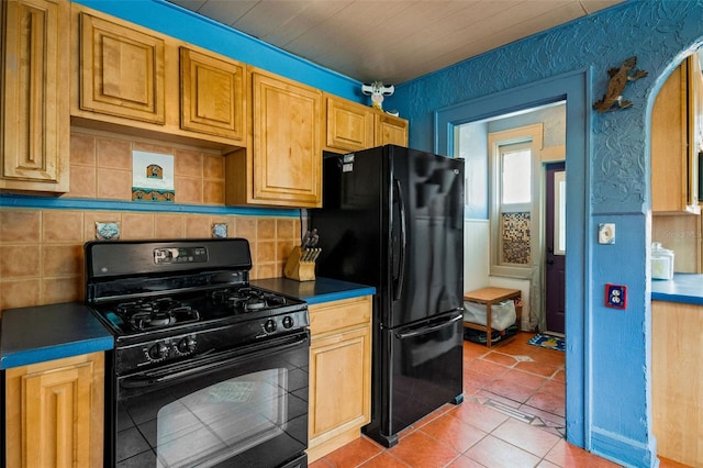 kitchen with black appliances, decorative backsplash, and light tile patterned flooring