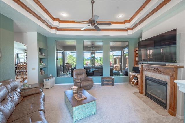 living room with light carpet, a raised ceiling, and ceiling fan