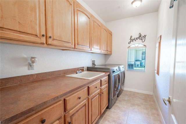 washroom featuring light tile patterned floors, cabinets, washer and dryer, and sink