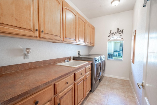 10177 Sunburst Ct, Spring Hill, FL 34608 - laundry area featuring washing machine and dryer, baseboards, a sink, cabinet space, and light tile patterned floors