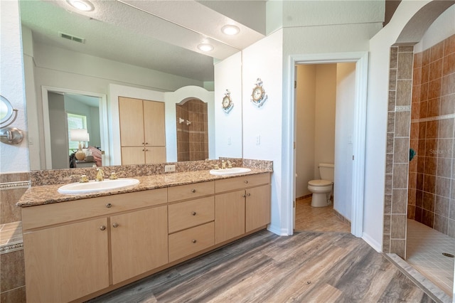 10177 Sunburst Ct, Spring Hill, FL 34608 - bathroom featuring a tile shower, a sink, ensuite bathroom, and wood finished floors