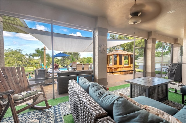 sunroom / solarium featuring ceiling fan and vaulted ceiling