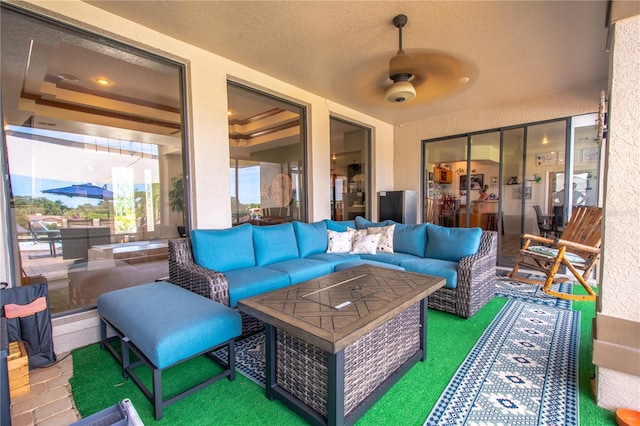 sunroom with a tray ceiling and ceiling fan