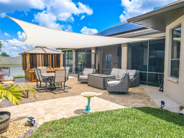 view of patio with an outdoor living space with a fire pit and a sunroom