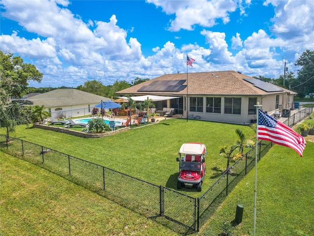 10177 Sunburst Ct, Spring Hill, FL 34608 - rear view of house with solar panels, a lawn, a patio area, a fenced in pool, and a fenced backyard
