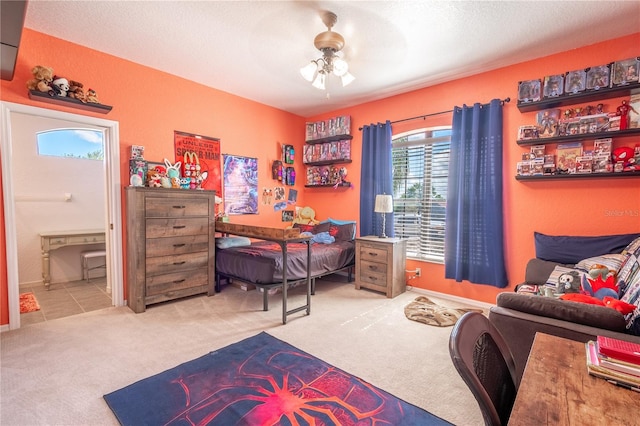 carpeted bedroom featuring ceiling fan, a textured ceiling, and ensuite bath