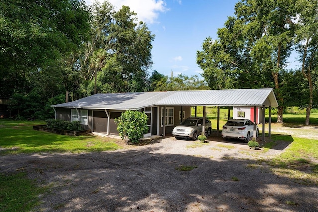 view of front of house featuring a sunroom, a front yard, and a carport