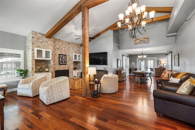 living room with dark wood-type flooring, high vaulted ceiling, beam ceiling, and a notable chandelier