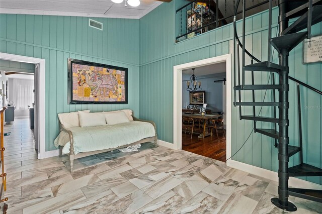 interior space with light hardwood / wood-style floors, a notable chandelier, high vaulted ceiling, and wooden walls