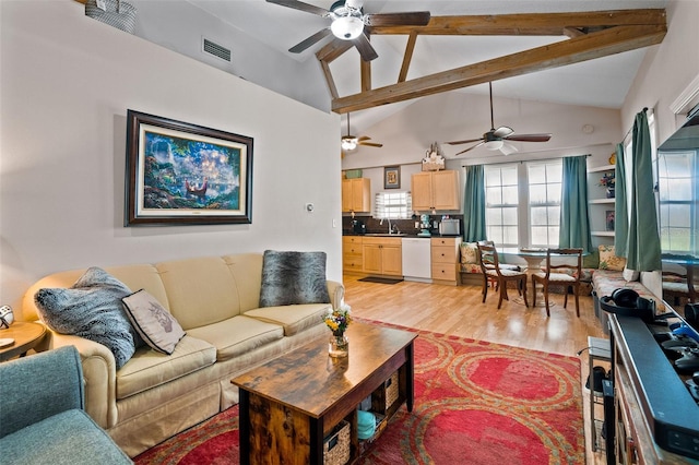 living room featuring light hardwood / wood-style flooring, sink, ceiling fan, and vaulted ceiling with beams