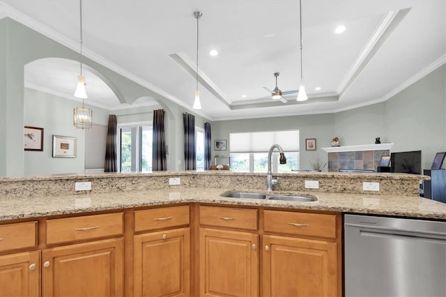 kitchen featuring light stone counters, a raised ceiling, a sink, and stainless steel dishwasher