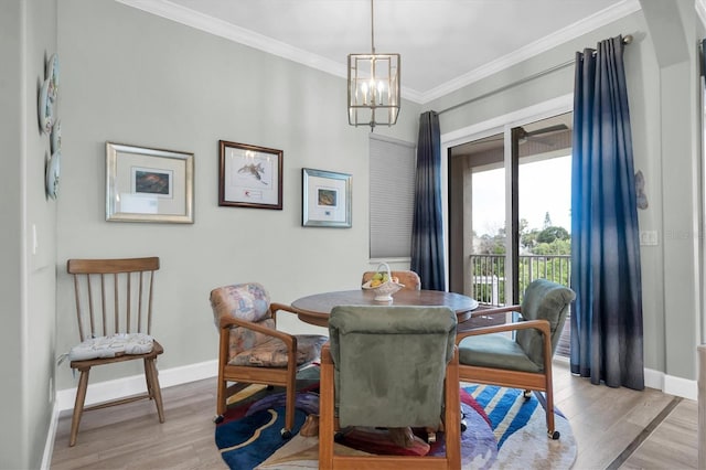 dining area featuring an inviting chandelier, light wood-style flooring, baseboards, and crown molding