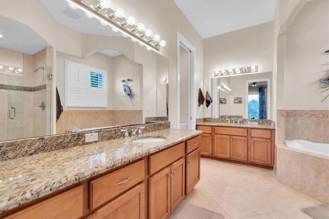 bathroom featuring a garden tub, two vanities, a sink, tile patterned floors, and a stall shower