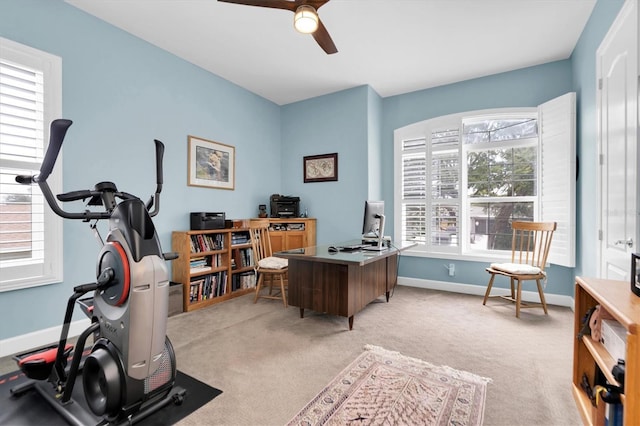 office featuring light carpet, ceiling fan, and baseboards