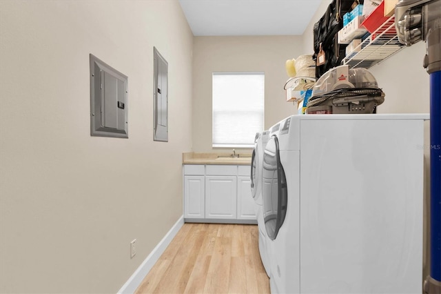 clothes washing area featuring cabinet space, electric panel, independent washer and dryer, and light wood finished floors