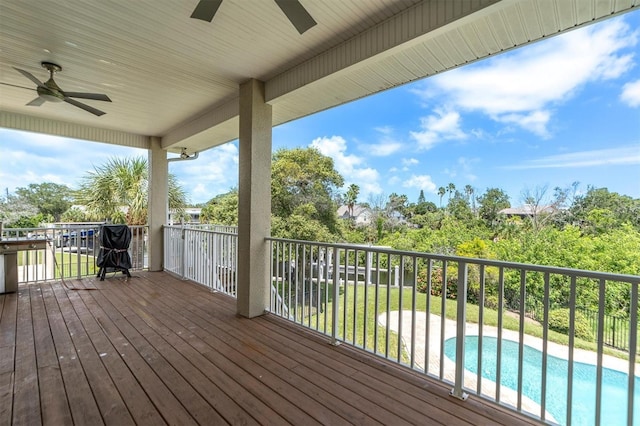 wooden terrace with ceiling fan and a yard