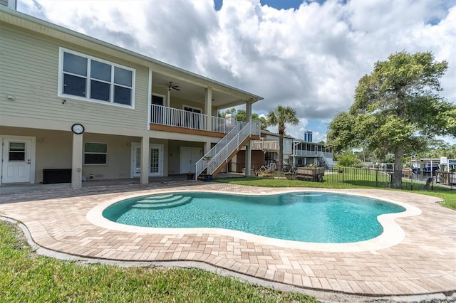 view of pool with a fenced in pool, a patio, ceiling fan, stairs, and fence