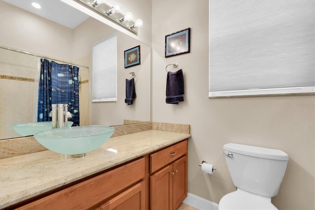 full bathroom with toilet, curtained shower, and vanity